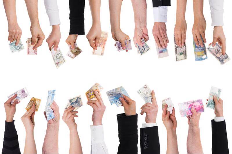 People holding different kinds of currencies. 